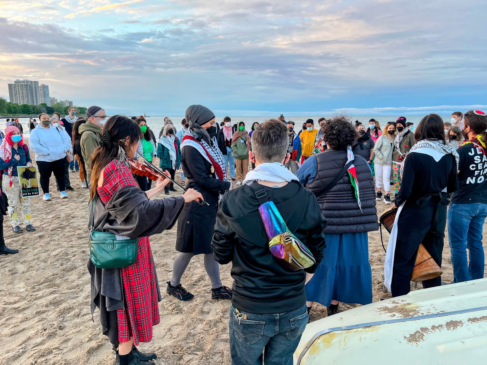 Musicians play for mourners on a beach.