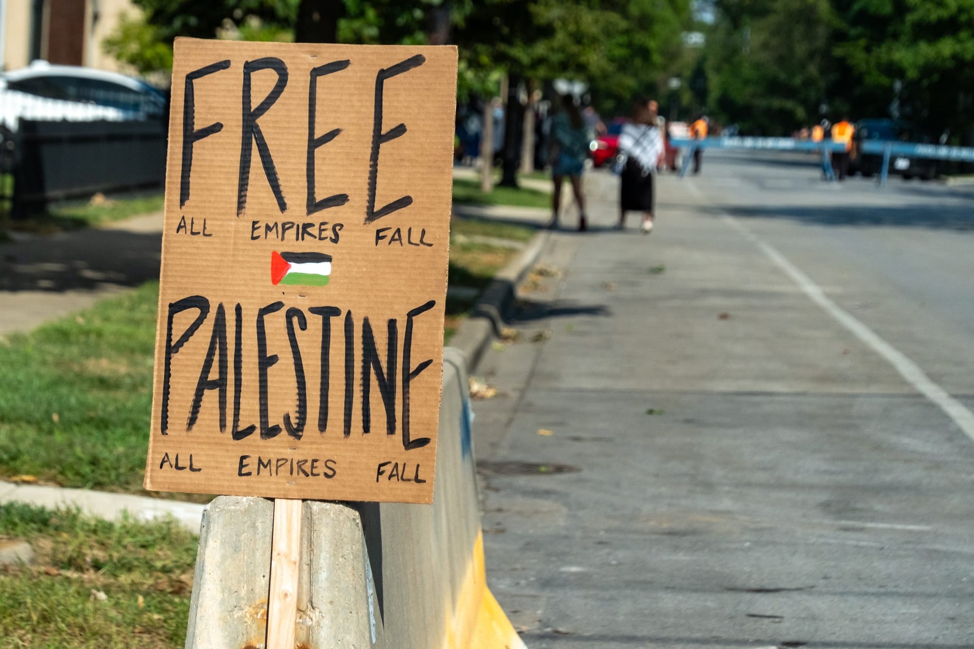 A sign left on a road barrier reads: "Free Palestine. All Empires Fall."