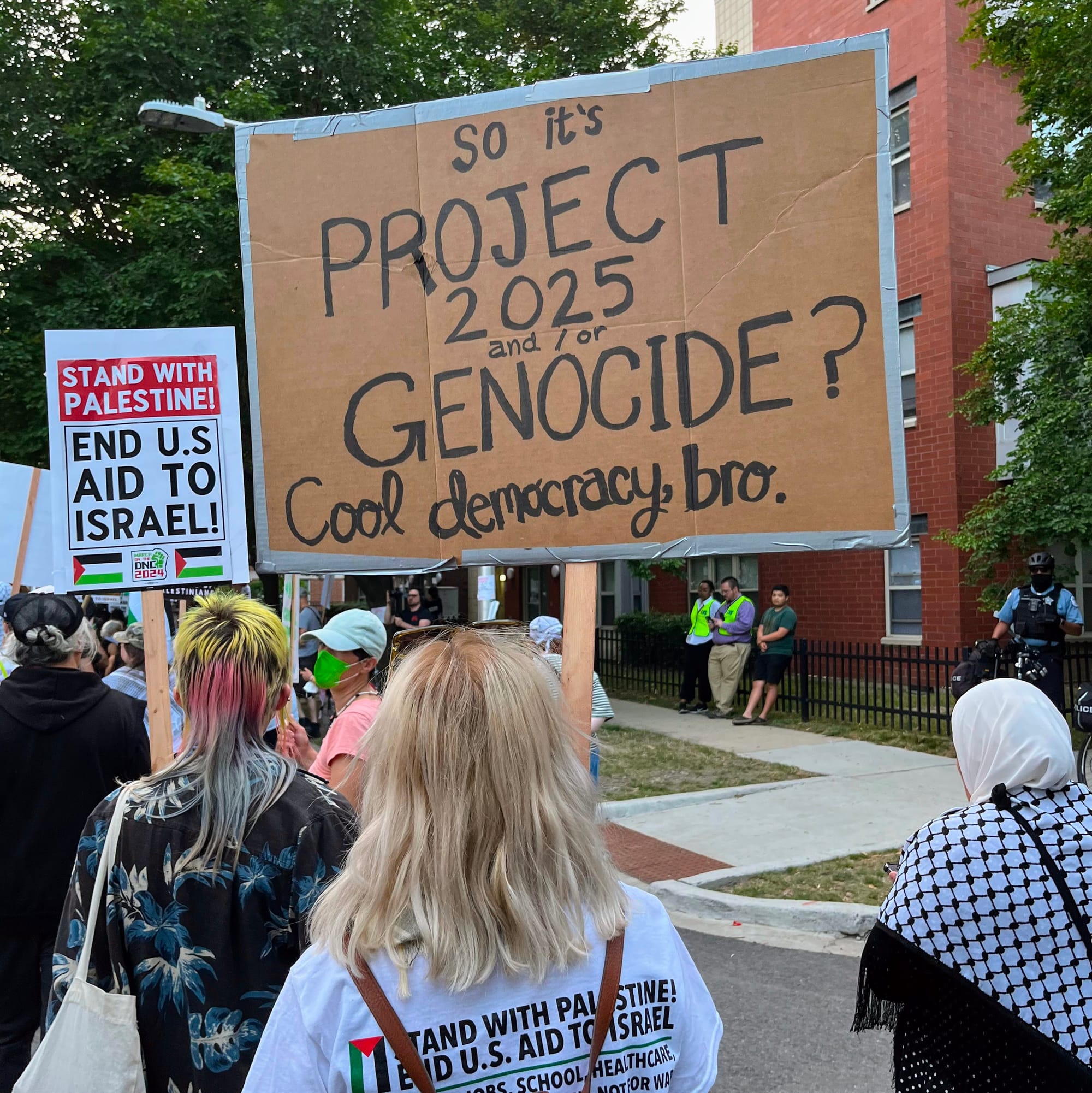 A protester's sign reads: "So it's Project 2025 or Genocide? Cool democracy, bro."