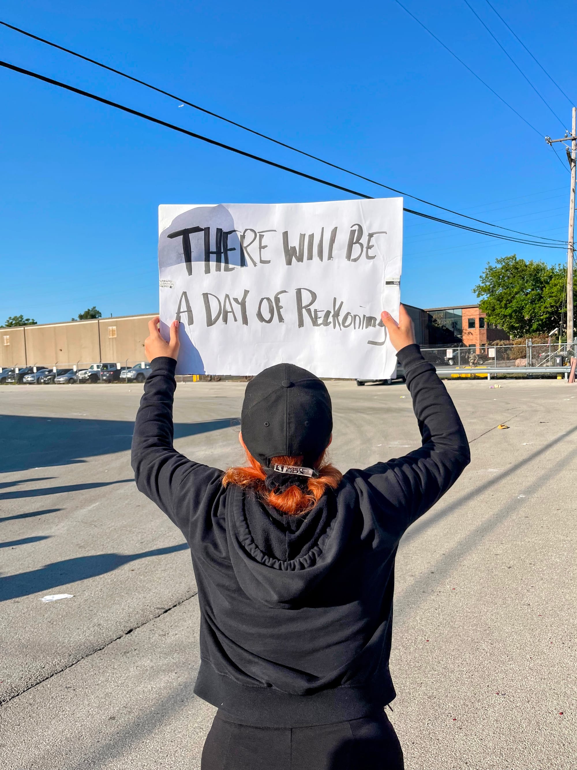 A protester holds a sign that reads: "There will be a day of reckoning."