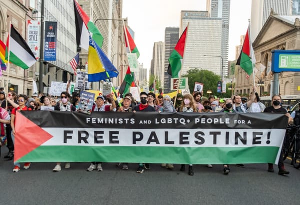 Protesters carry a banner that reads "Feminists and LGBTQ+ People for a Free Palestine."