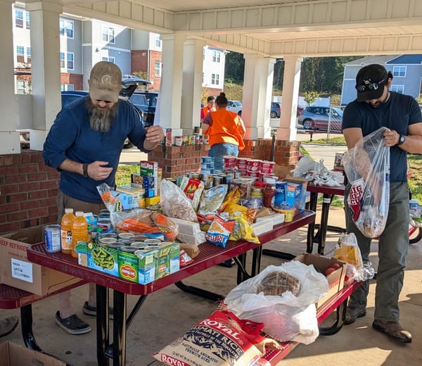 Two volunteers sort donations on a picnic table in Asheville, North Carolina.